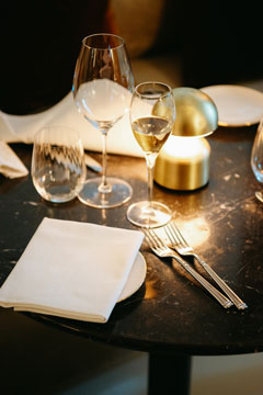 Gedeckter Tisch mit vollem Weisswein Weinglas