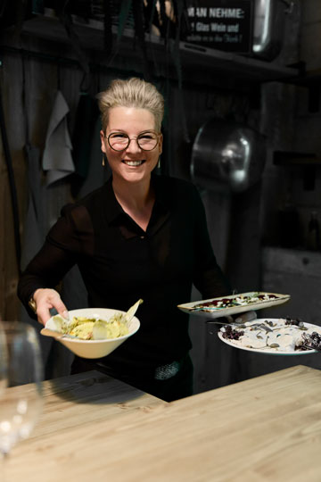 Lina Walter serviert und lächelt in die Kamera